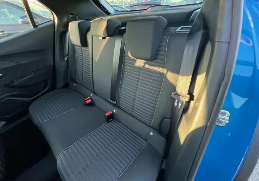 Vue intérieure sur la banquette arrière noire du Peugeot 2008 2024, avec portière bleu Vertigo Metal ouverte côté droit.