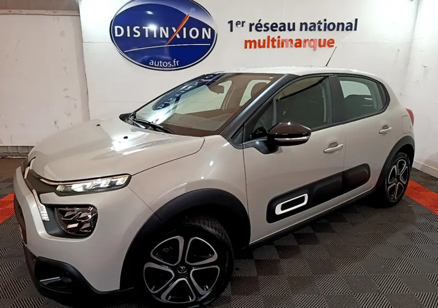 Citroën C3 beige vue 3/4 avant droit, avec protections latérales noires et jantes distinctives en alliage.