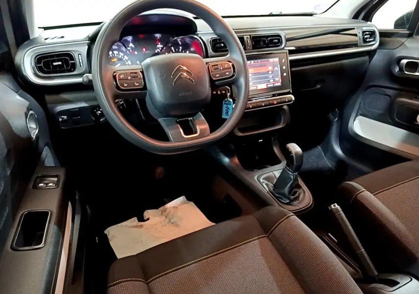 Vue intérieure avant de la Citroën C3 beige 2022, volant multifonctions, écran tactile 7 pouces et boîte manuelle.