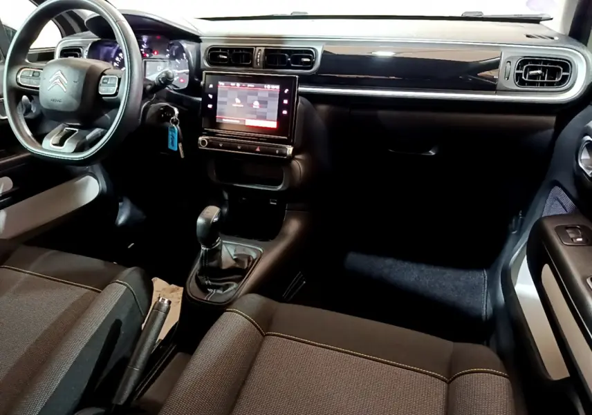 Intérieur de la Citroën C3 beige, vue côté conducteur, tableau de bord avec écran tactile central et volant multifonctions.