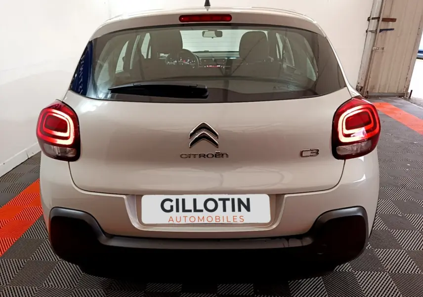 Vue arrière d'une Citroën C3 beige 2022 avec feux arrière LED et logo centré sur un fond intérieur.