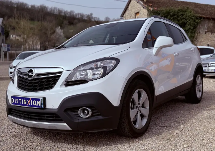 Opel Mokka X blanc vue 3/4 avant droit, avec calandre noire et jantes alliage cinq branches.