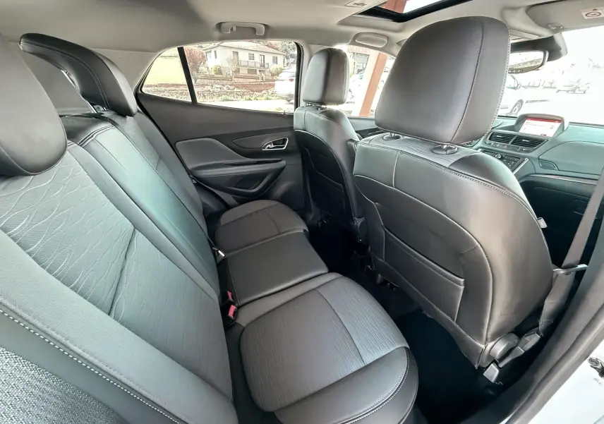 Vue intérieure arrière montrant les sièges arrière en cuir noir et tissu gris du Opel Mokka X blanc.
