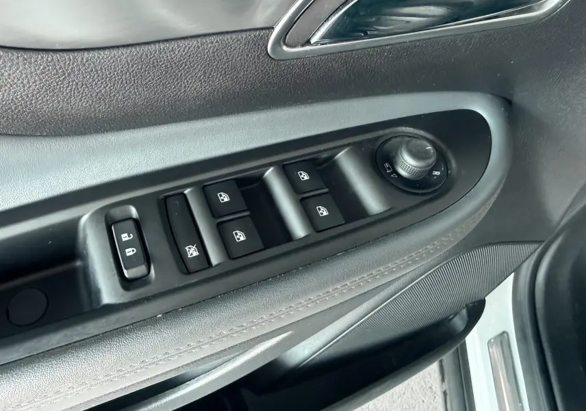 Gros plan sur la commande des vitres et rétroviseurs côté conducteur de l'Opel Mokka X, intérieur noir.