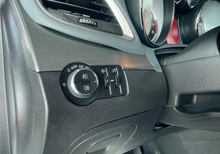 Vue intérieure côté conducteur de l'Opel Mokka X 2016, détail des commandes d'éclairage sur tableau de bord noir.