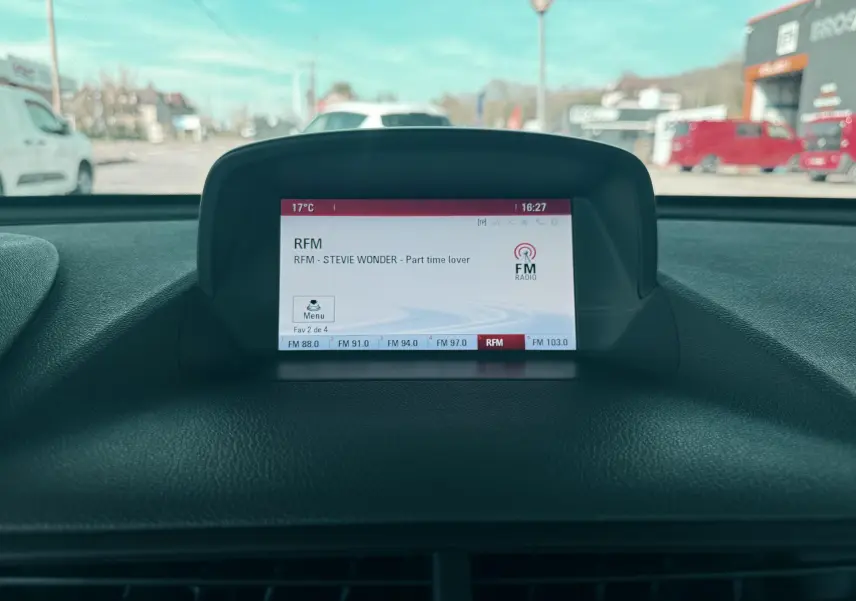 Écran central de l’Opel Mokka X 2016 affichant la radio FM avec vue partielle du tableau de bord noir.