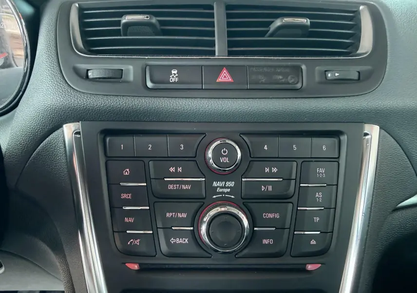 Vue rapprochée du tableau de bord noir de l’Opel Mokka X 2016, mettant en valeur la console centrale avec commandes audio et navigation.