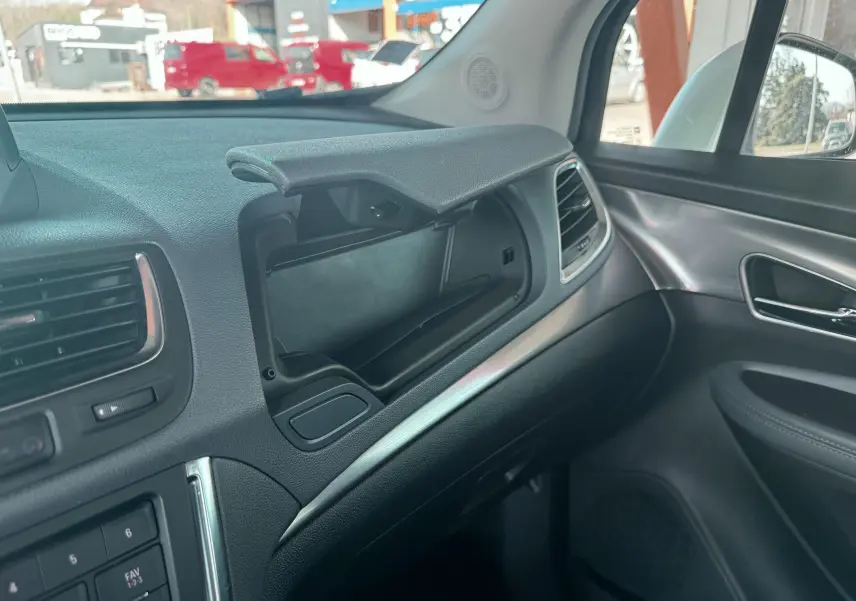 Intérieur de l'Opel Mokka X 2016, vue côté passager sur la boîte à gants ouverte et garnitures grises et noires.