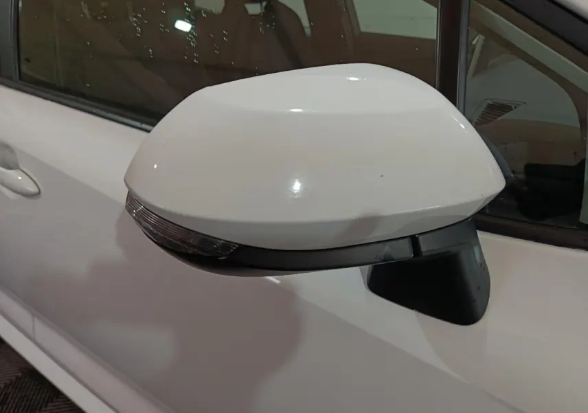 Rétroviseur électrique blanc côté gauche de la Toyota Corolla hybride 2022, avec clignotant intégré.