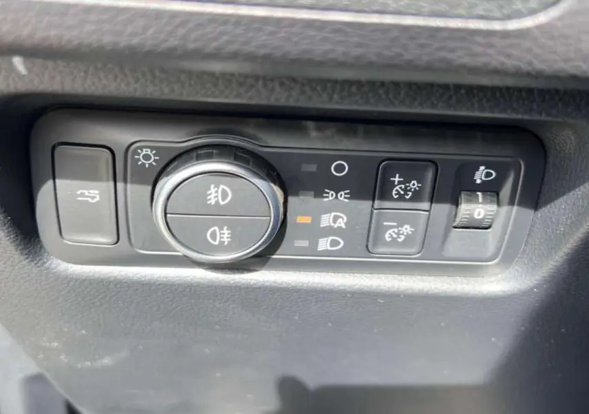 Gros plan sur les commandes d’éclairage et réglage de hauteur des phares du Ford Ranger noir agate 2025.