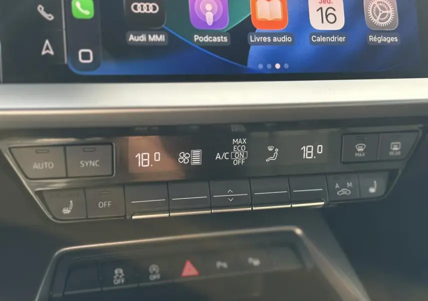 Panneau de climatisation automatique à deux zones de l'Audi A3 Sportback 30 TFSI noir, avec réglages affichés à 18 degrés.