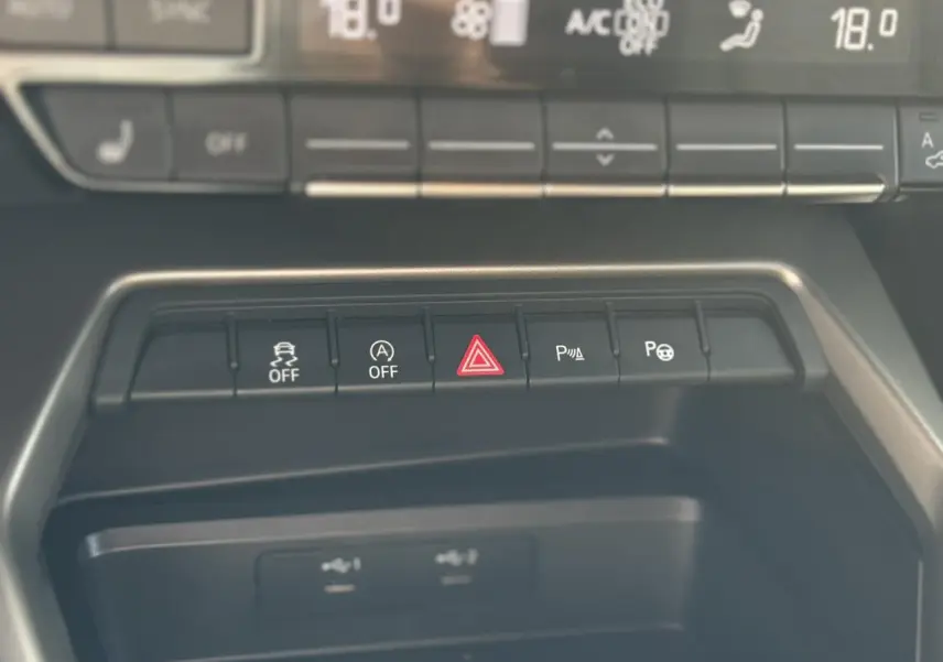 Gros plan sur la console centrale de l'Audi A3 Sportback 2023, boutons de contrôle et ports USB visibles.