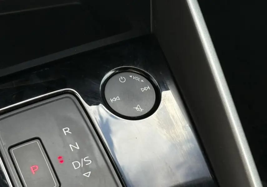 Gros plan sur la console centrale de l'Audi A3 Sportback 30 TFSI 110 S-Tronic Design avec commandes audio et levier de vitesses.