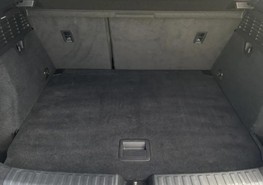 Coffre spacieux vu de face, revêtement noir, avec fixations Isofix et tapis de sol dans un Audi A3 Sportback 2023.