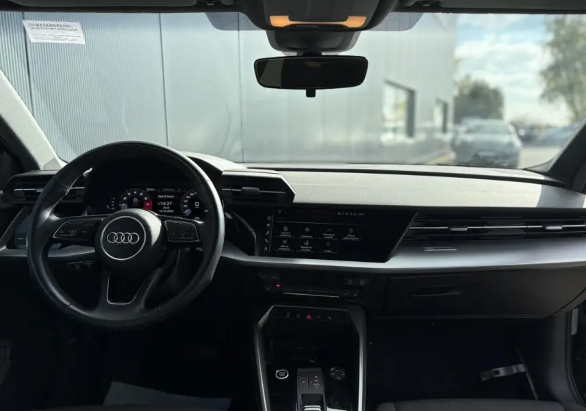 Vue intérieure de l'Audi A3 Sportback 2023 avec tableau de bord moderne et volant cuir noir Mythe.