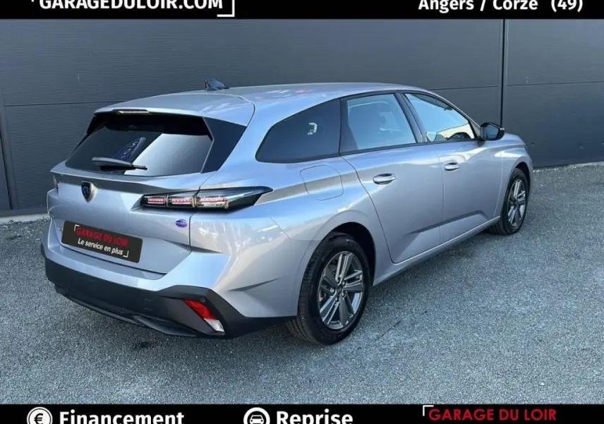 Vue 3/4 arrière droite d'une Peugeot 308 gris clair 2023 avec feux LED et vitres teintées.