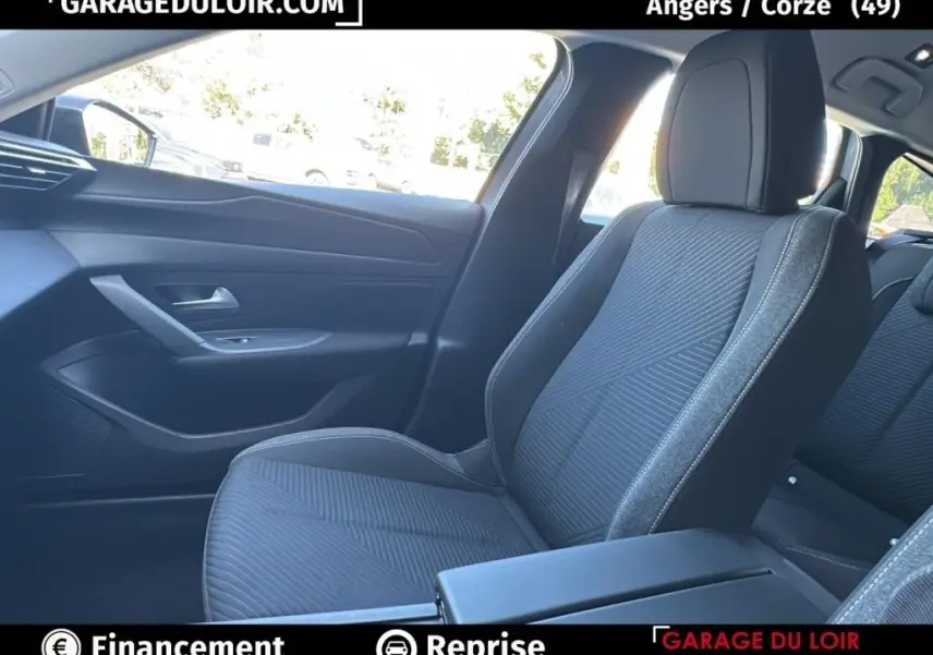 Vue intérieure côté passager avant du Peugeot 308 gris clair 2023, sièges tissu avec surpiqûres contrastées.