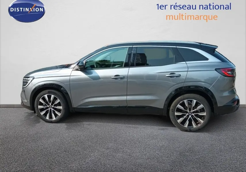 Profil latéral gauche d'un Renault Austral gris schiste métallisé, mettant en valeur ses jantes bi-ton et sa silhouette SUV moderne.