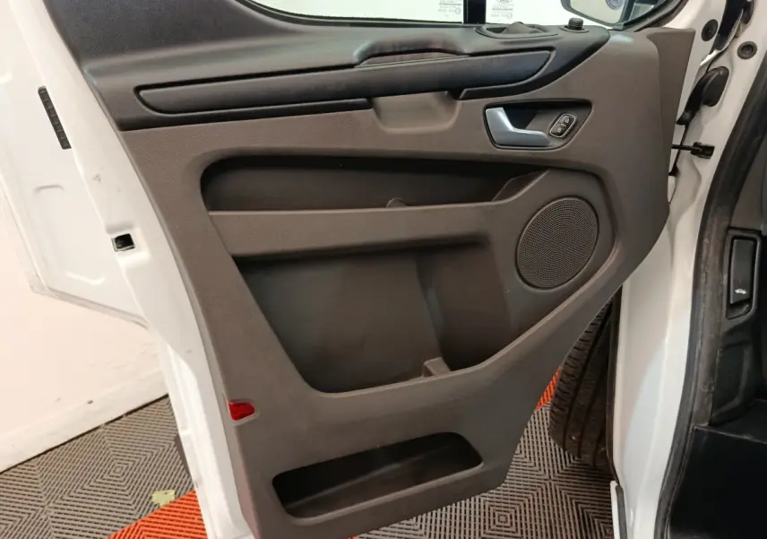 Vue intérieure de la porte avant droite blanche du Ford Transit Custom Fourgon, avec panneau noir et commande de vitre.