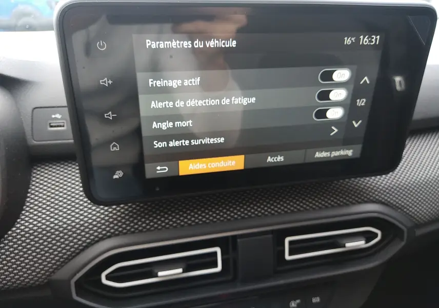 Écran tactile central intérieur de la Dacia Sandero gris 2024 affichant les paramètres d’aides à la conduite.