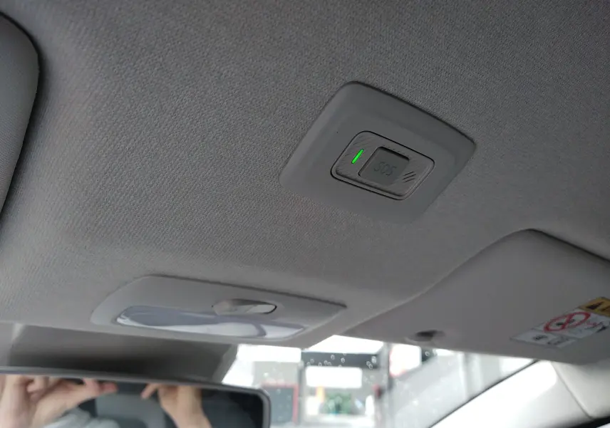 Détail du plafonnier gris clair avec bouton SOS et lumière intérieure dans une Dacia Sandero 2024.