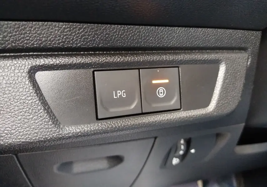 Gros plan sur les boutons de commande LPG et verrouillage dans l’habitacle noir de la Dacia Sandero 2024 gris.