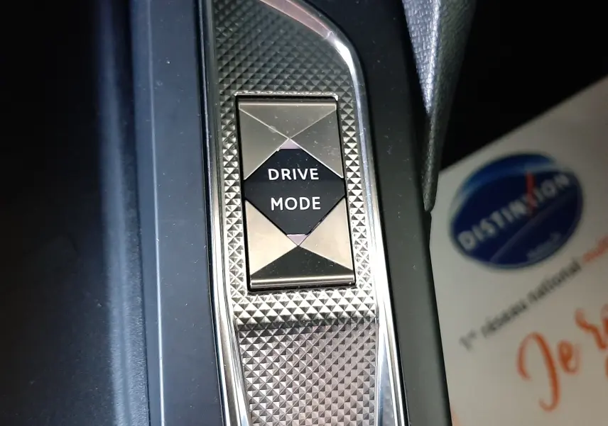 Bouton Drive Mode en gros plan sur la console intérieure du DS3 Crossback gris platinium métal, finition texturée et chrome.