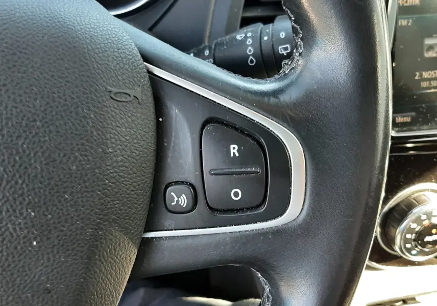Gros plan sur le volant en cuir noir du Renault Captur 2018, montrant les commandes audio et le tableau de bord partiel.