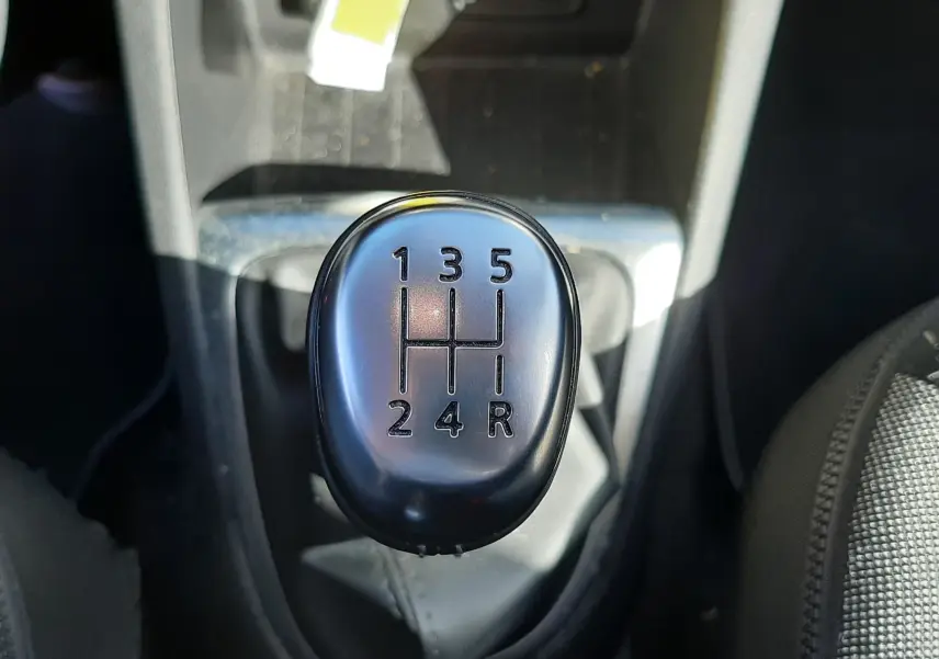 Le levier de vitesses manuel noir du Renault Captur 2018 en gros plan, entouré de l'habitacle sombre.