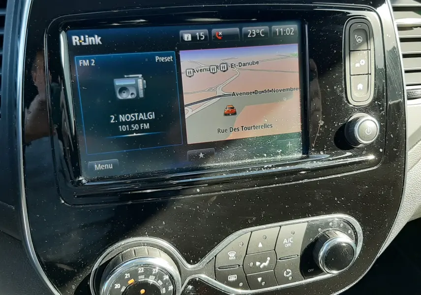 Vue rapprochée de l'écran tactile R-Link et de la console centrale noire du Renault Captur gris cassiope avec toit noir.