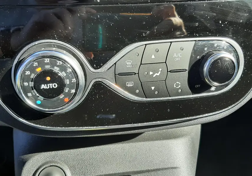 Gros plan sur la console centrale du Renault Captur gris cassiope avec commandes de climatisation et bouton start/stop.