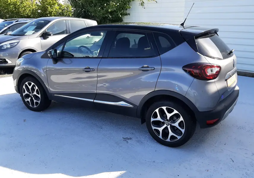 Renault Captur 2018 gris Cassiopée avec toit noir, vue de profil côté gauche, jantes alliage bi-ton visibles.