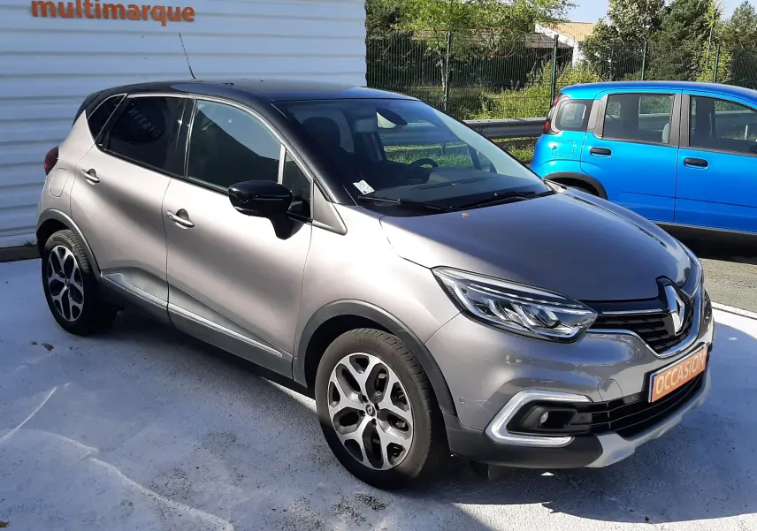Renault Captur 2018 gris cassiope avec toit noir, vue 3/4 avant droit, jantes alliage et calandre distinctive.