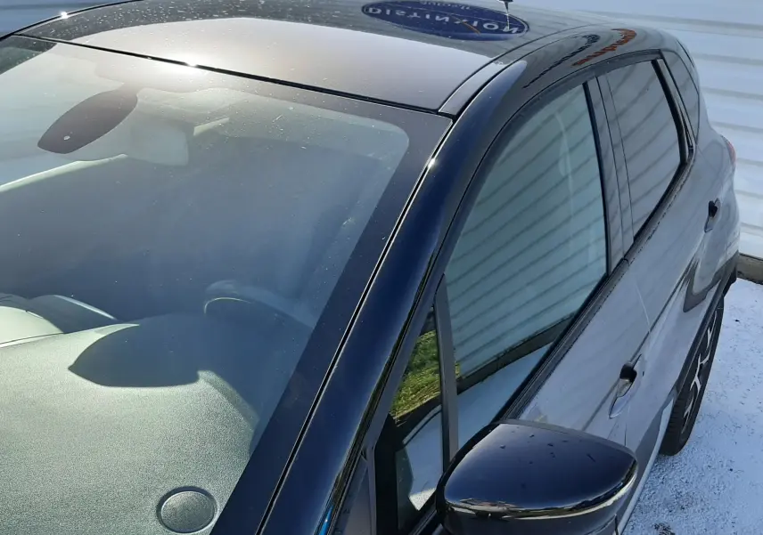 Vue 3/4 avant droit du Renault Captur gris Cassiope avec toit noir brillant et rétroviseur droit noir.