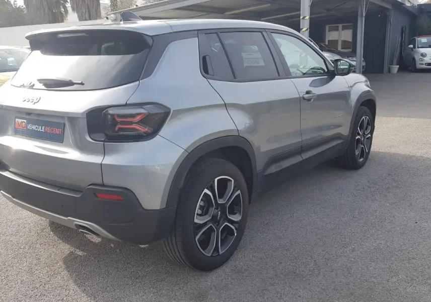 Vue 3/4 arrière droite d’un Jeep Avenger gris avec jantes alliage 18 pouces et feux arrière au design moderne.