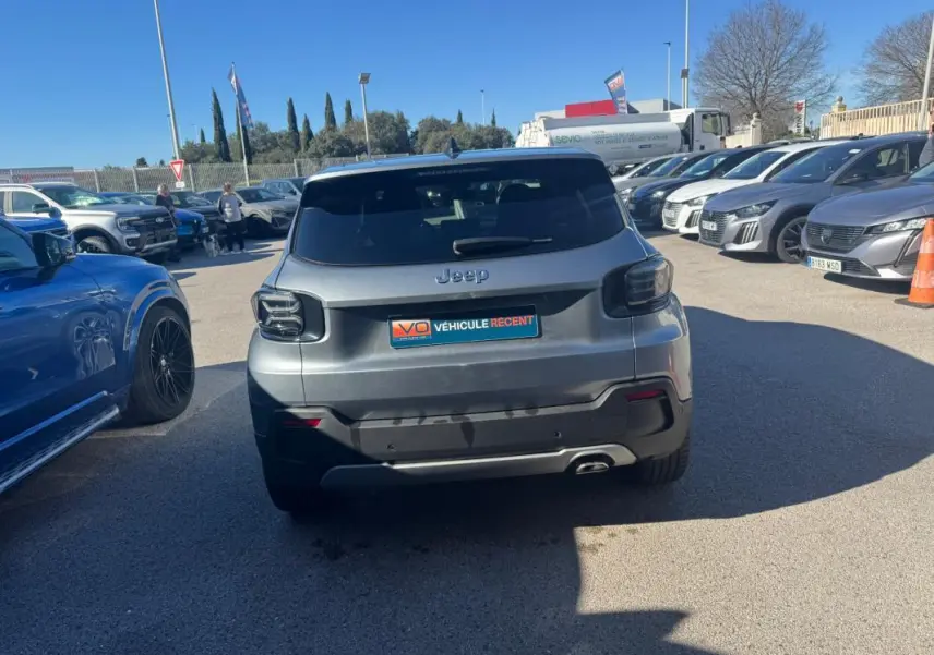 Vue arrière d'un Jeep Avenger gris 2025 garé en extérieur, avec feux arrière sombres et plaque "Véhicule récent".