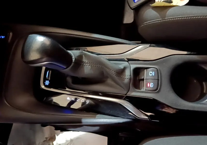 Gros plan sur la console centrale avec levier de vitesses automatique en cuir noir du Suzuki Swace gris clair.