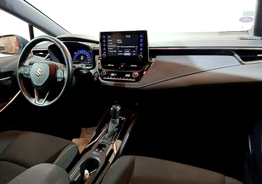 Vue intérieure avant du Suzuki Swace 1.8 Hybrid Privilege 2021, tableau de bord noir avec écran tactile central et volant cuir.