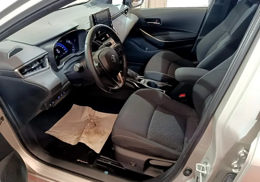 Vue intérieure côté conducteur de la Suzuki Swace gris clair, volant cuir multifonctions et tableau de bord digital.