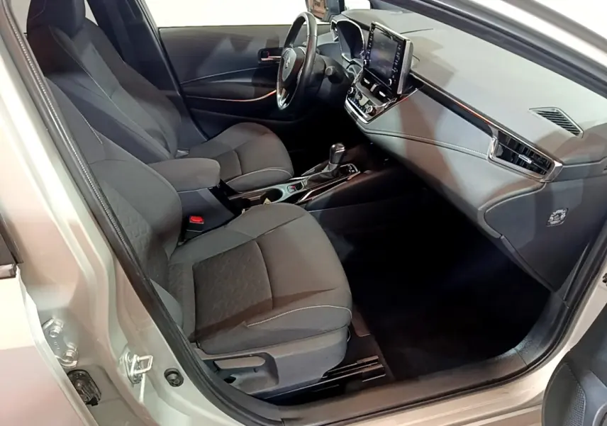 Intérieur avant droit d'une Suzuki Swace gris clair, montrant sièges tissu et tableau de bord avec écran tactile.