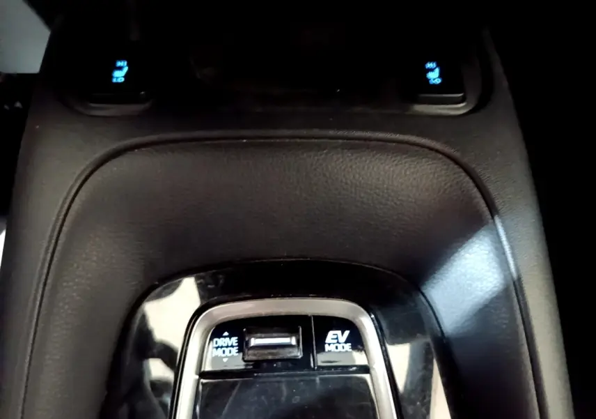 Vue rapprochée du sélecteur de modes de conduite sur la console centrale noire du Suzuki Swace gris clair hybride.