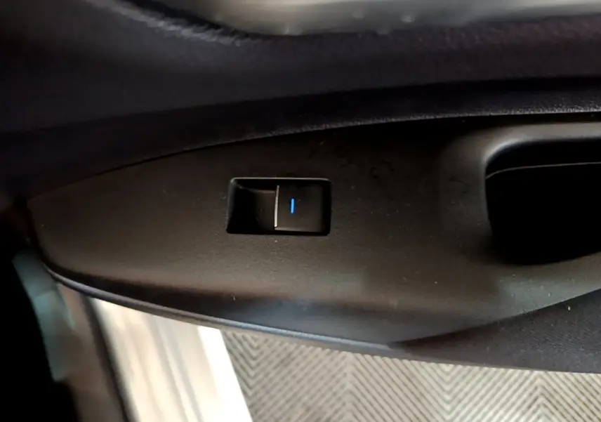 Bouton de commande de verrouillage sur la portière côté conducteur d'une Suzuki Swace gris clair 1.8 Hybrid Privilege.