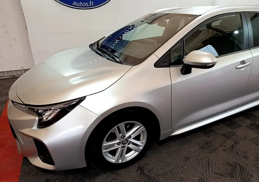 Vue 3/4 avant droit d'une Suzuki Swace gris clair avec jantes alliage et rétroviseur assorti.