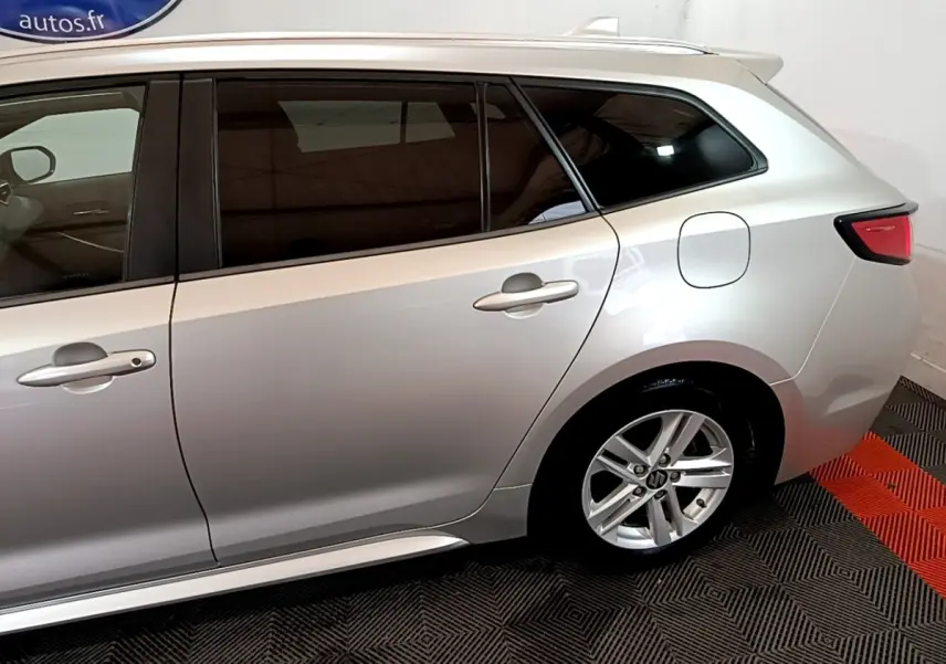 Vue latérale droite sur l'arrière d'une Suzuki Swace gris clair avec jante alliage et vitres teintées.