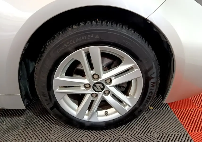 Gros plan sur la roue arrière droite d'une Suzuki Swace 1.8 Hybrid Privilege gris clair, avec pneu Michelin visible.