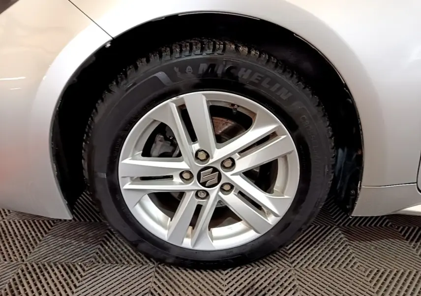 Gros plan sur la roue avant droite gris clair d'une Suzuki Swace 1.8 Hybrid Privilege avec jante alliage.