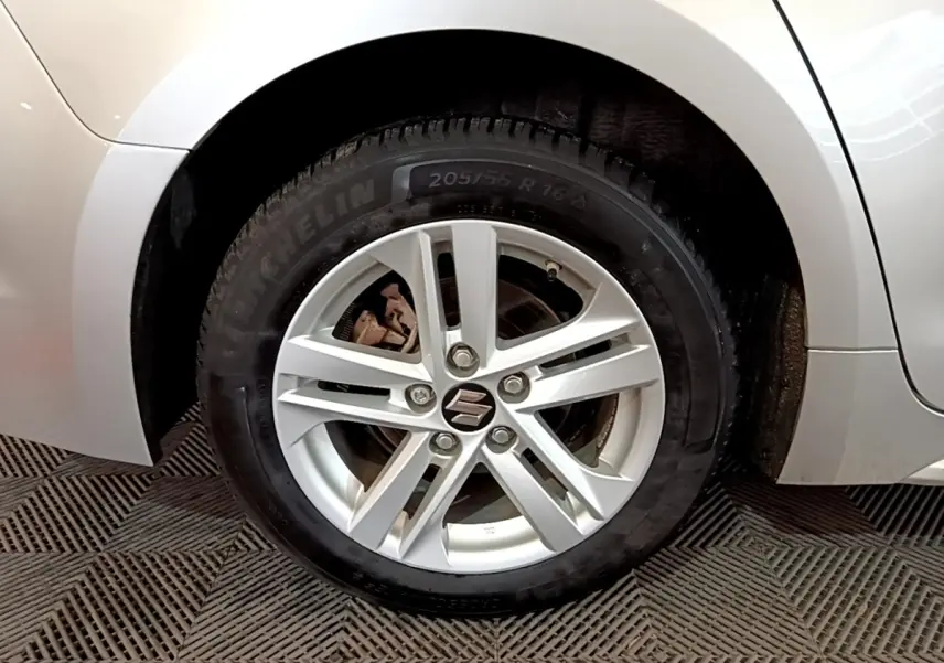 Gros plan sur la roue arrière droite d'une Suzuki Swace gris clair, montrant l'aile et une partie de la carrosserie.