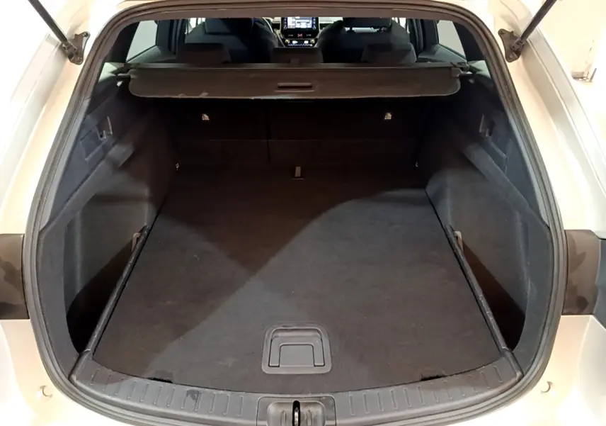 Coffre ouvert vu de l'arrière d'une Suzuki Swace gris clair, montrant l'espace de chargement et l'intérieur sombre.