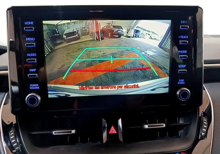 Écran tactile central montrant la caméra de recul avec lignes de guidage dans un Suzuki Swace gris clair.