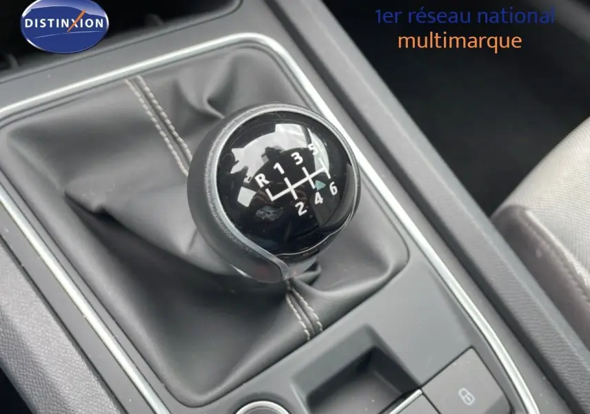 Gros plan sur le levier de vitesses manuel noir de la SEAT LEON ST 2.0 TDI 115CH STYLE XL, intérieur gris et tissu visible.